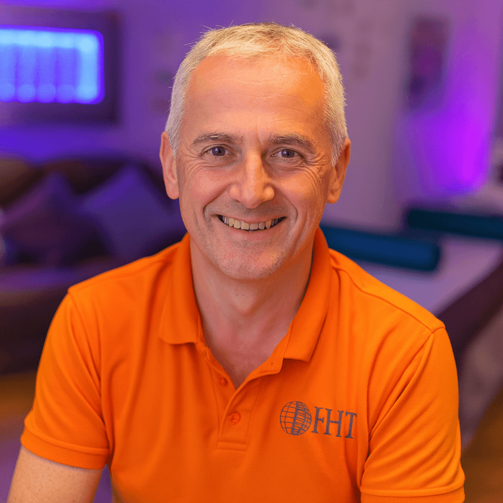 Ed Goodwin, professional male holistic therapist, smiling in his calming treatment room in Weston-super-Mare