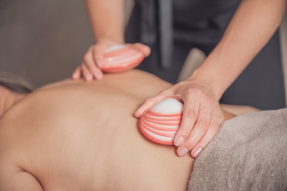 Therapist performing a calming lava shell back massage to relieve muscular tension and promote relaxation in Weston-super-Mare