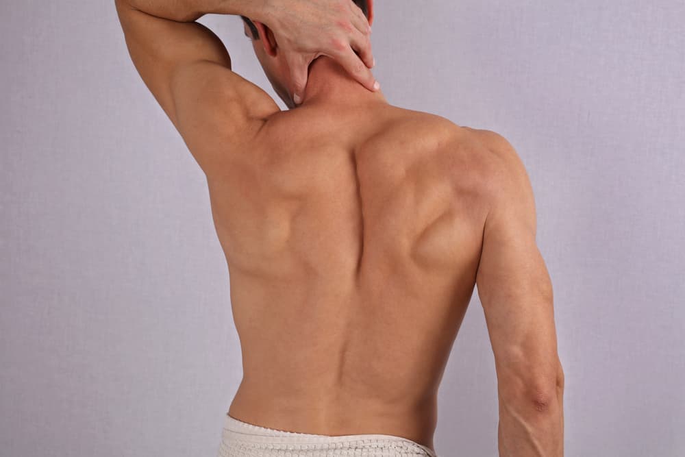 Back view of a man with smooth, hair-free skin on his back, shoulders and neck, showing the results of a professional waxing treatment.