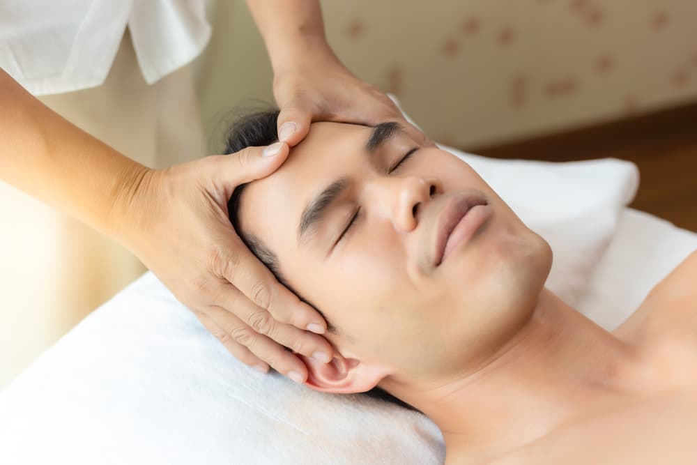 Man receiving a calming facial massage as part of a 90-minute sensual massage and Tropic Skincare treatment in Weston-super-Mare