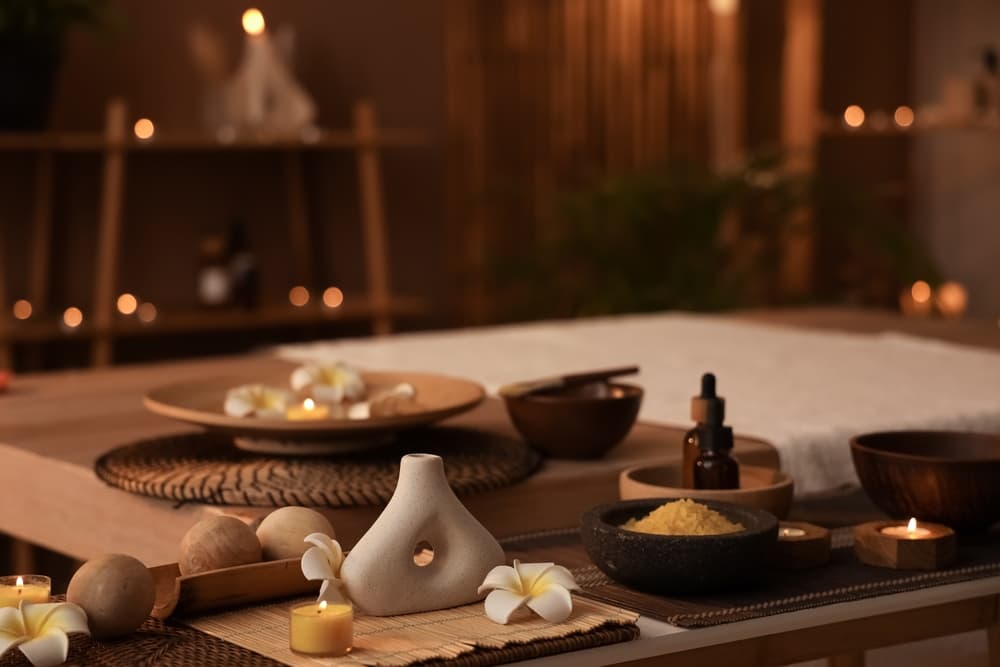 Luxury massage room with soft lighting, oils, and candles prepared for a two-therapist synchronised sensual massage in Weston-super-Mare