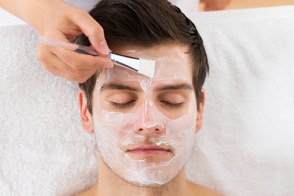 Man receiving a hydrating Tropic facial with soothing cream mask applied in a relaxing treatment room in Weston-super-Mare